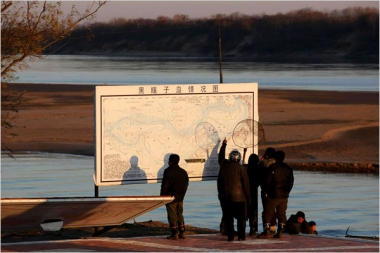 Chinese fishermen looked at a map of Heixiazi Island in China near the Russian border. China and Russia unveiled boundary markers delineating the eastern section of their border, hailing the agreement as an example for the rest of the world in solving territorial disputes. (Reuters)